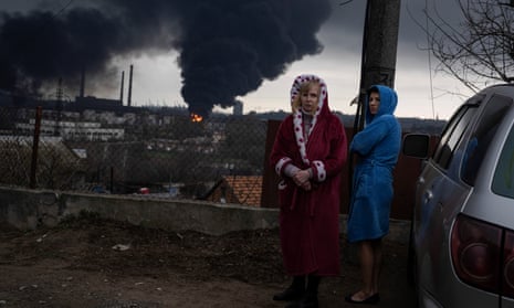 Women stand next to a car as smoke rises in the air in the background after shelling in Odesa, Ukraine, Sunday, 3 April 2022. 