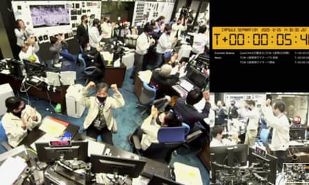 Japan’s space agency staff celebrate the successful separation of a capsule carrying material from an asteroid from the Hayabusa2 spacecraft.