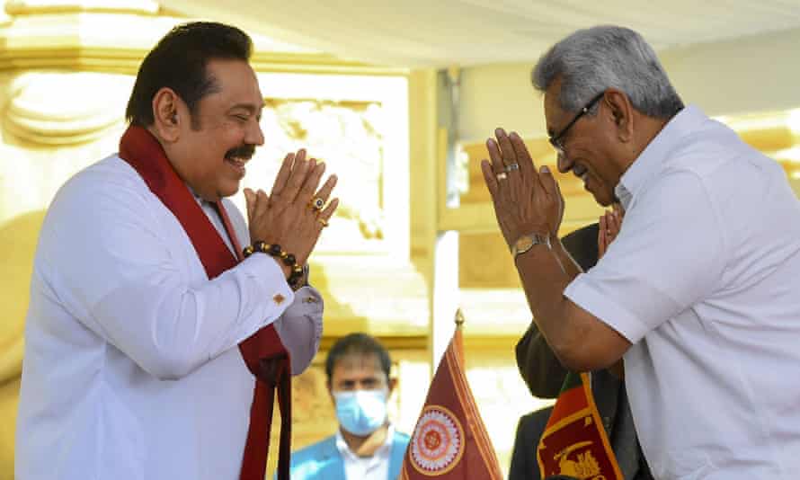 In this file photo taken on August 9, 2020, Sri Lakan President Gotabaya Rajapaksa (right) swears in his elder brother Mahinda Rajapaksa (left) as Sri Lanka’s new Prime Minister at the sacred Kelaniya Raja Maha Buddhist temple, outside the capital Colombo.