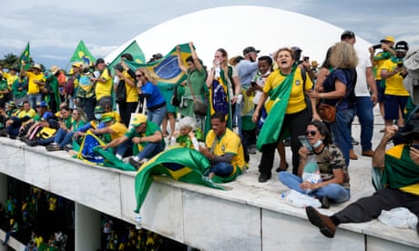Protesters, supporters of Brazil's former President Jair Bolsonaro, stand on the roof of the National Congress building after they stormed it, in Brasilia, Brazil, Sunday, Jan. 8, 2023. (AP Photo/Eraldo Peres)