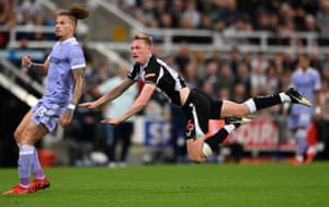 Sean Longstaff of Newcastle United is seen in midair as he watches his shot alongside Kalvin Phillips of Leeds.