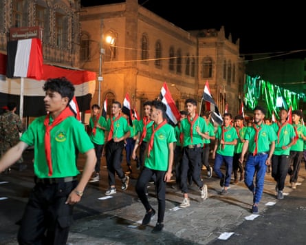 A night-time march by youths wearing green.