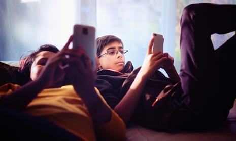 Teenagers looking at mobile phones