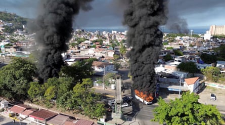 Smoke billows from burning vehicles in Puerto Vallarta amid a wave of violence following a military operation in which Mexican drug lord El Mencho was killed.