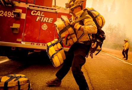 A firefighter carries multiple rolls of hose