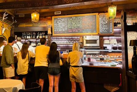 Customers line up at the bar beneath the wines-by-the-glass board at Antica Bottega del Vino.