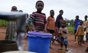 Children watch as women pump water from a borehole near Malawi’s capital Lilongwe.