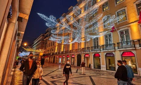 Pedestrians wearing protective masks walk under the Christmas and New Year colour-changing illuminations in Rua Augusta during the COVID-19 Coronavirus pandemic on 23 November 2020 in Lisbon, Portugal.