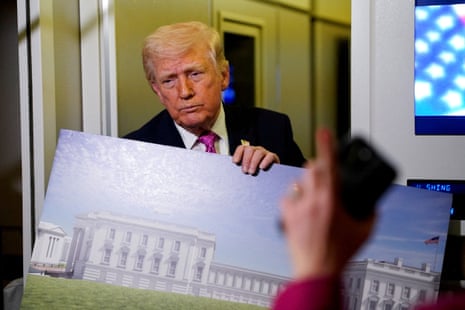 President Donald Trump talks while holding up renderings of the planned White House ballroom