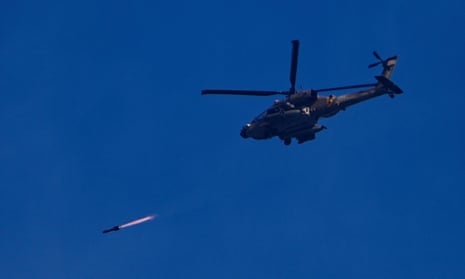 An Israeli Apache helicopter fires a missile in direction of the Gaza Strip, as seen from southern Israel, 6 December.
