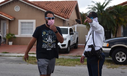 A policeman directs a citizen where to pick up an unemployment form in Miami, Florida, earlier this month.