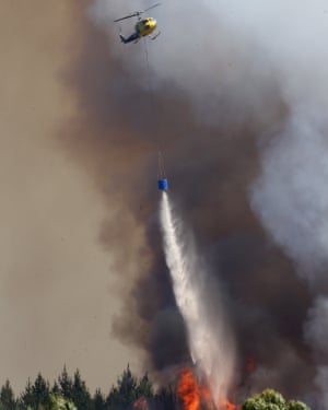 A helicopters dumps water on a fire near Nelson, New Zealand. A helicopters dumps water on a fire near Nelson, New Zealand.