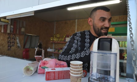 Mohammed, 30, prepares espresso cafe in his kiosk next to the broken security fence.