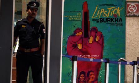 A security guard at the entrance to a cinema in Mumbai next to a poster for Lipstick Under My Burkha