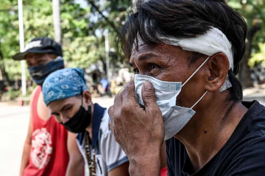 Marlon and Tisay Adesas and Alan Yongco with bandages wrapped around his head. Yongco had run out of meal coupons to distribute and had been attacked by an irate homeless person