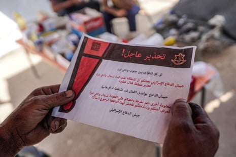 A Palestinian reads an Israeli leaflet in Arabic in Deir el-Balah in the central Gaza Strip on 16 April.
