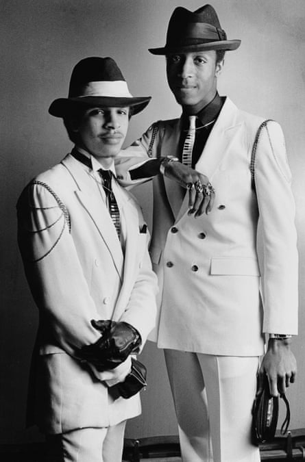 two men in suits and hats stand beside each other in portrait
