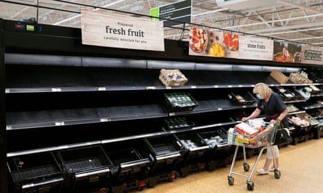 A woman wearing a face mask near empty fruit and veg shelves in an Asda store in July 2021 in Cardiff.