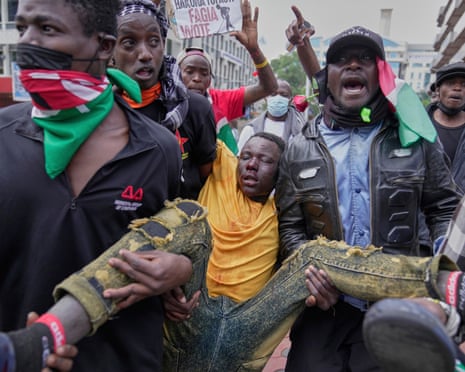 A man is carried by protesters after being beaten by anti riot police during a demonstration in downtown Nairobi on Wednesday.