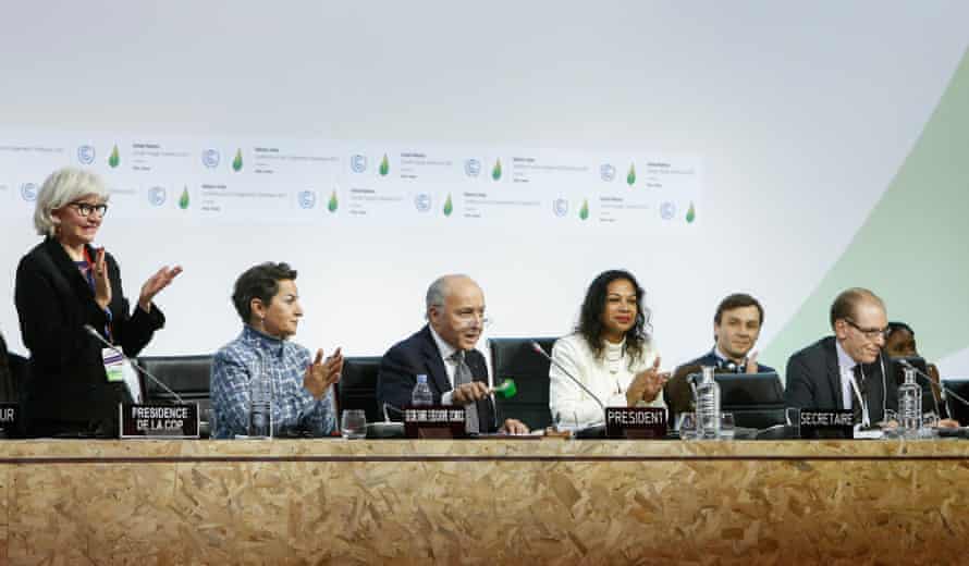 Then French foreign minister and Cop21 president Laurent Fabius (third from left) marks the adoption of the Paris agreement on 12 December 2015