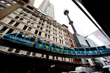 A farewell Sydney sign on the side of the monorail with Centrepoint Tower in view behind it.