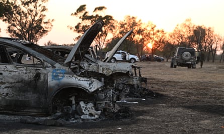 Burnt out cars at the Supernova festival site at sunset