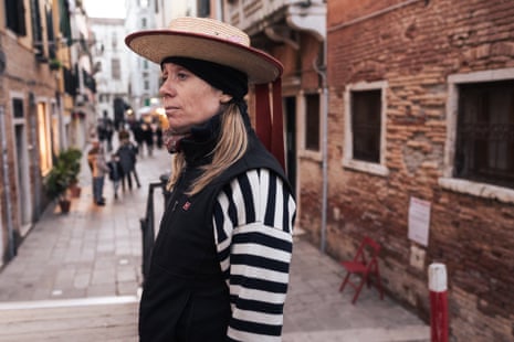 Chiara Curto posing sideways in a black and white striped shirt, black fleece jerkin and boater hat