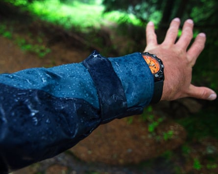 Closeup of a man’s arm in rain with raincoat and watch