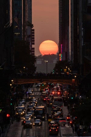 The sun sets as seen between buildings along 42nd Street