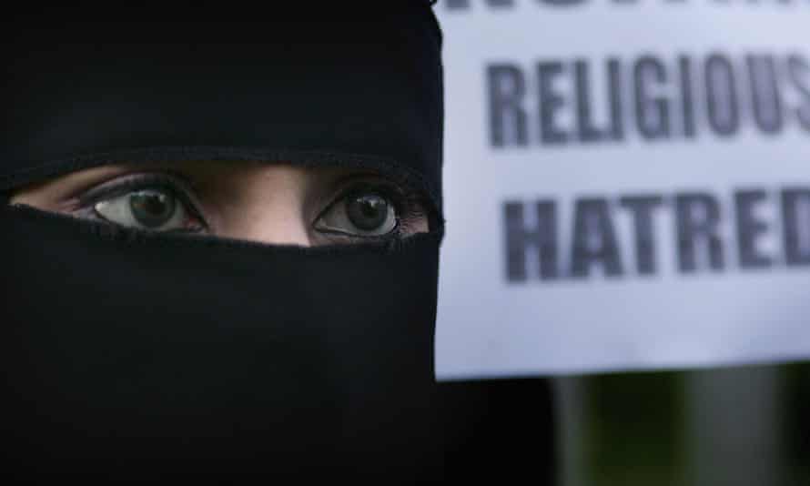 A Muslim woman wearing a niqab veil protests outside Bangor Street Community centre against comments Jack Straw made about the veil.