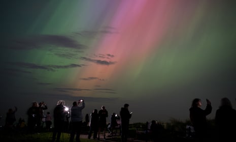 People watch the northern lights at St Mary's lighthouse, Whitley Bay, north-east England.