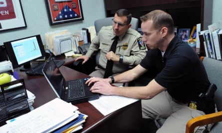 Officer Michael Chindblom (right) and assistant police chief Luther Reynolds work on their crime database.