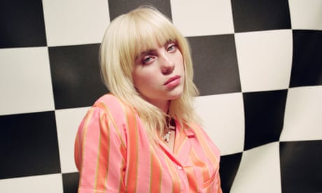 Billie Eilish in pink stripy outfit against black and white checked background