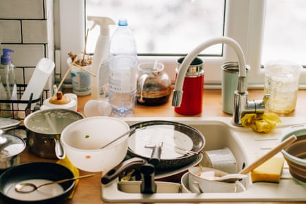 Overflowing sink full of dirty dishes and utensils