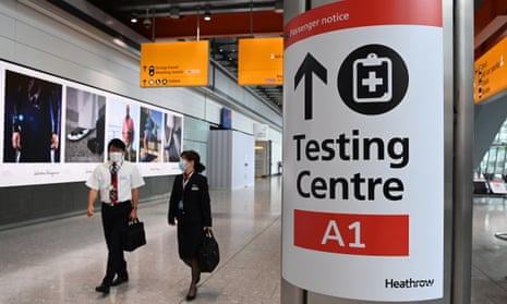 cabin crew pass a covid test centre sign at heathrow