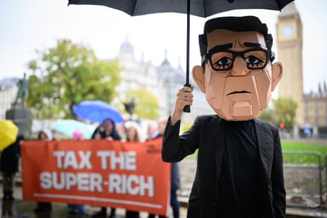 A campaigner wears a cardboard mask of Britain's prime minister Andy Burnham.