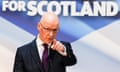 John Swinney points towards the camera as he speaks, in front of a banner that reads 'Stronger for Scotland' (only the final two words can be seen in the picture)