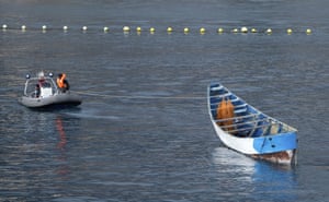 A wooden boat carrying the bodies of migrants who died trying to reach Europe is towed by emergency services to Los Cristianos port, Tenerife, Spain.