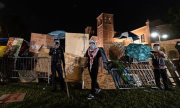 Pro-Palestinian demonstrators rebuild a barricade surrounding the encampment at UCLA 