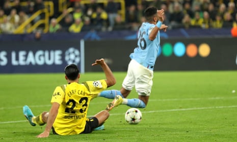 Dortmund’s Emre Can (left) fouls Riyad Mahrez of Manchester City in the penalty box and the referee points to the spot.