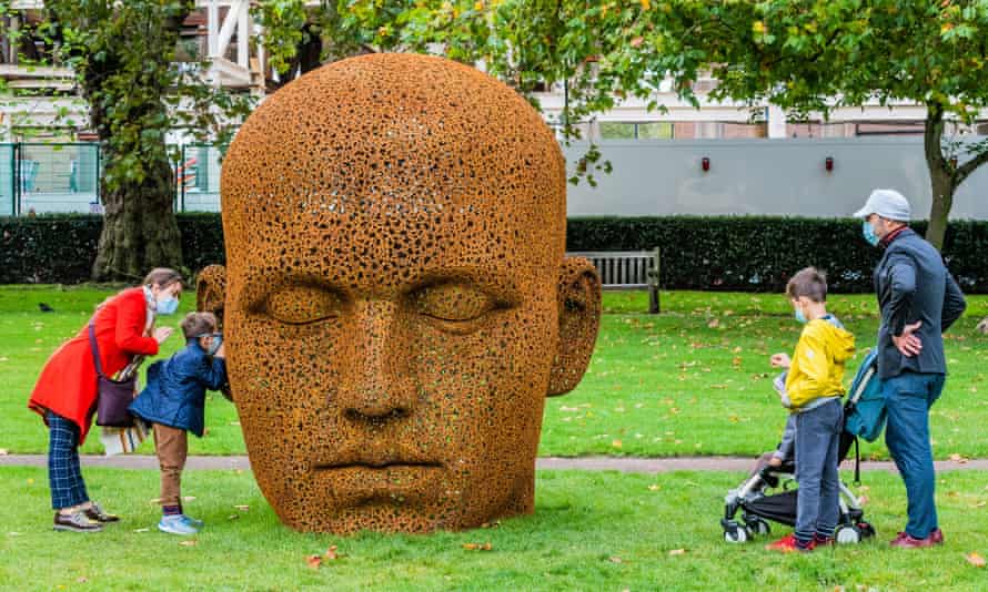 A family look at a massive head sculpture