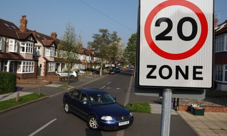 A street sign reading '20 zone' on a suburban street