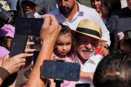 Lula embraces a child among a crowd of supporters