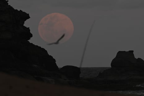 A full moon rises ahead of a total lunar eclipse in Stanwell Park, south of Sydney.