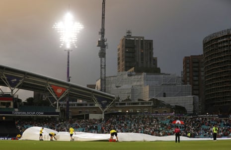 round staff bring out covers as rain delays play