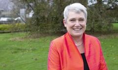 Kate Bingham wearing an orange jacket and standing on some grass