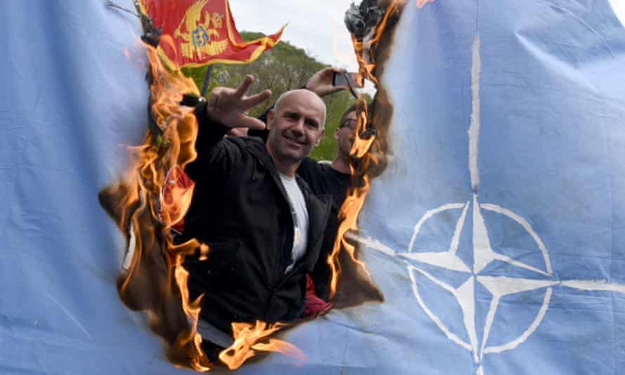 Demonstrators burn a Nato flag