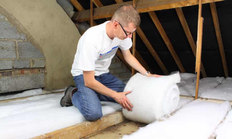 A man unrolling roof insulation in the loft