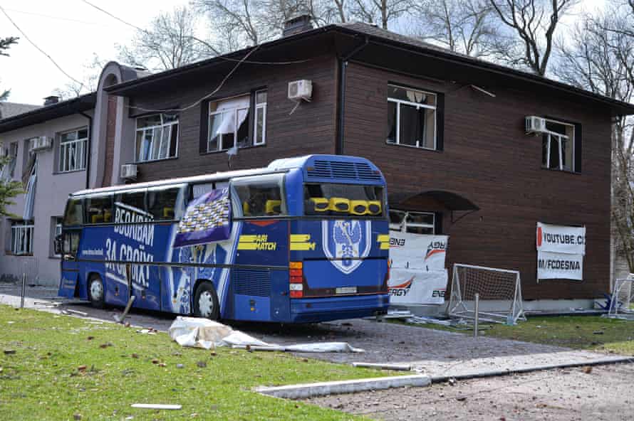 A team bus next to a damaged building at the training center