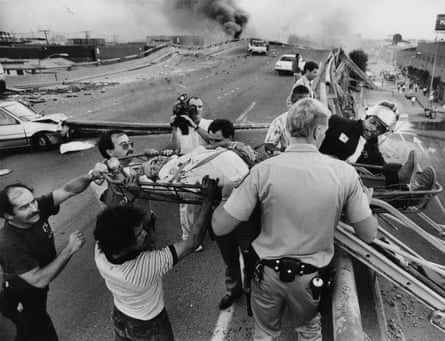 Officials and others evacuate a man, Erick Carlson, from the Cypress section of Highway 17, now called Interstate 880, in Oakland, California, following the Loma Prieta earthquake.